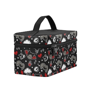 May include: Black cosmetic bag with a repeating pattern of bats, skulls, hearts, clouds, and stars. The bag has a black handle and zipper. The bag is rectangular and has a black top.