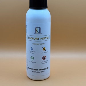 以下が含まれることがあります： 黒いキャップと「7Senses Innovations LUXURY HOTEL 香り付きスプレー」と書かれたラベルが付いた白いスプレーボトル。ラベルには、水性フォーミュラ、消臭剤、空気の香り、抗菌作用のアイコンも含まれています。ボトルには「4 US FL OZ (118 ML)」と「SHAKE WELL BEFORE USE」のラベルが付いています。