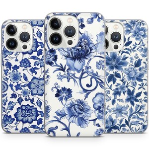 May include: Three iPhone cases with a blue and white floral pattern. The cases are clear and show the phone's camera lenses.