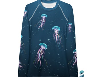 Puede incluir: Camiseta de manga larga azul oscuro con un estampado de medusas luminosas. Las medusas están representadas en tonos azules, rosas y morados, con detalles de estrellas blancas. La camiseta tiene cuello redondo blanco y mangas raglán.