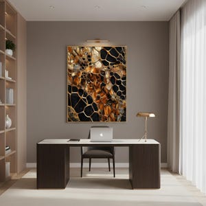 Puede incluir: Un entorno de oficina con un escritorio de madera oscura con una parte superior blanca, una computadora portátil y una silla moderna. Una gran obra de arte abstracta con tonos dorados, negros y marrones cuelga de la pared. También se ven una lámpara de escritorio dorada y una estantería.