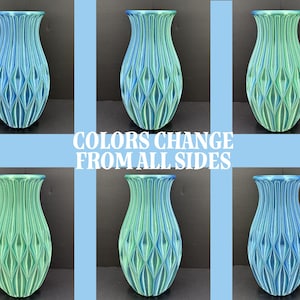 May include: Six ceramic vases with a blue and green color gradient. The vases have a unique, textured design with a diamond pattern. The text "COLORS CHANGE FROM ALL SIDES" is displayed in the center of the image.