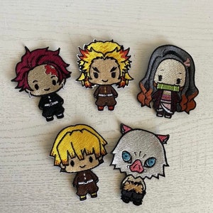 May include: Five embroidered iron-on patches featuring characters from the anime Demon Slayer. The characters are Tanjiro, Zenitsu, Inosuke, Nezuko, and Giyu. The patches are colorful and detailed.