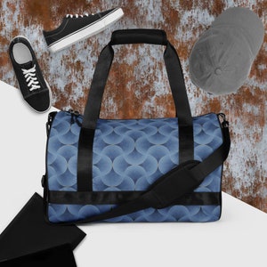 May include: A blue and black duffel bag with a geometric pattern. The bag has a top handle and a shoulder strap.