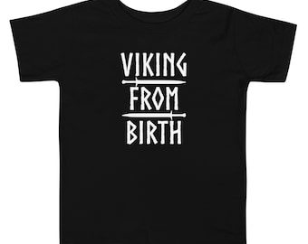 Op de afbeelding: Zwart T-shirt voor peuters met witte tekst "Viking From Birth" met twee zwaarden boven en onder de tekst.