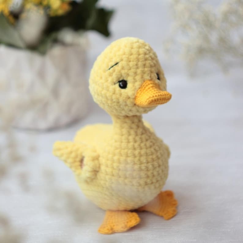 Peut inclure: Un caneton crochet&eacute; &agrave; la main, de couleur jaune, avec un bec et des pieds orange vif. Le caneton a de petits yeux noirs et une expression l&eacute;g&egrave;rement triste. La laine douce et textur&eacute;e cr&eacute;e un jouet charmant et fantaisiste.