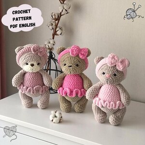 May include: Three handmade crochet teddy bears in a row, each with a pink dress and bow. The bears are light brown and beige, with a white background. The text "CROCHET PATTERN PDF ENGLISH" is in a cloud-shaped bubble.
