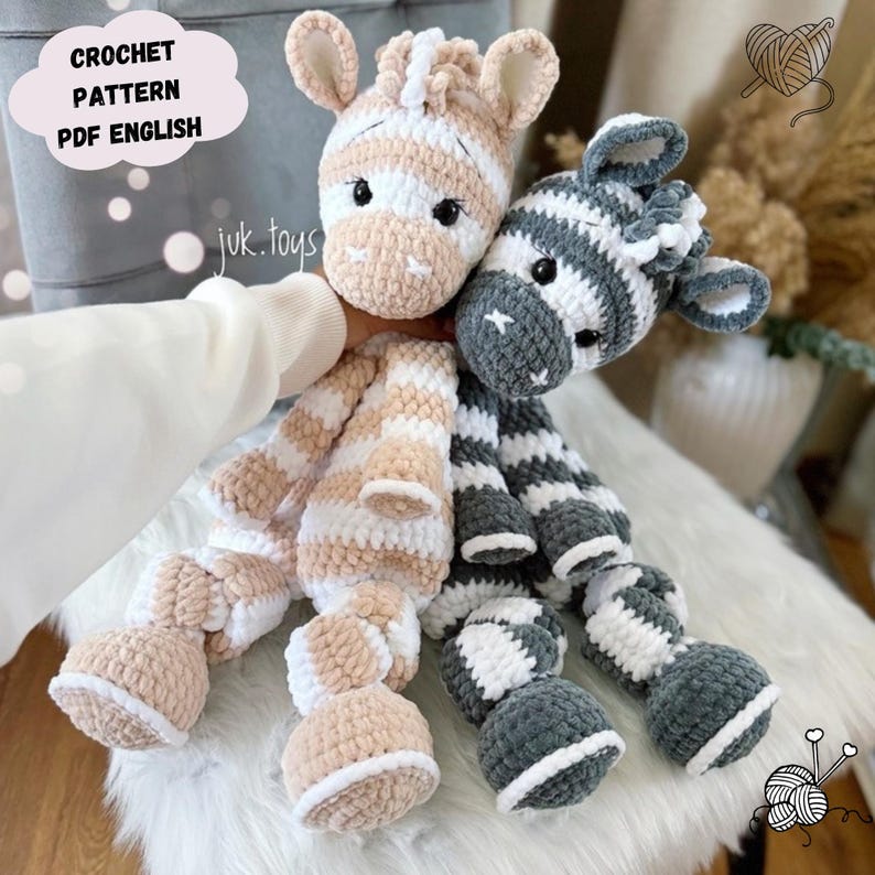May include: Two handmade crochet zebra plushies. One is tan and white, the other is gray and white. The plushies have long bodies and large feet. The text "CROCHET PATTERN PDF ENGLISH" is in a cloud-shaped text box.