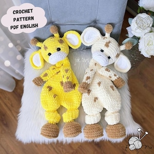 Puede incluir: Dos doudous de jirafa tejidos a mano, uno en amarillo brillante y otro en crema, ambos con manchas marrones, hocicos blancos y pezuñas marrones. Un globo de texto en la esquina superior izquierda dice CROCHET PATTERN PDF ENGLISH y juk.toys.