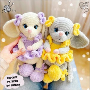 Könnte beinhalten: Zwei gehäkelte Mäuse-Spielzeuge, eine weiße mit einem lila Kleid und die andere graue mit einem gelben Kleid. Beide haben blaue Augen und rosa Nasen.