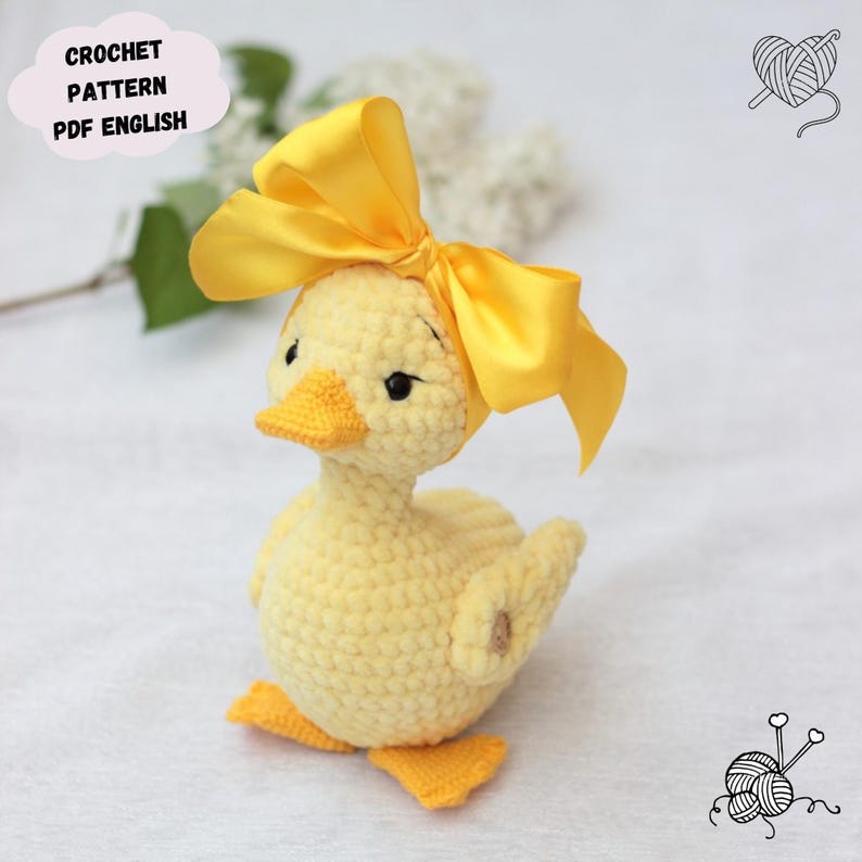 Peut inclure: Un caneton au crochet jaune fait &agrave; la main avec un n&oelig;ud jaune vif. Le caneton a un bec et des pieds jaunes. Le texte "CROCHET PATTERN PDF ENGLISH" est dans une zone de texte en forme de nuage. Un article charmant et fait &agrave; la main.