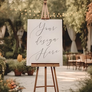 Puede incluir: Un caballete de madera con un cartel blanco que dice "Your design here" en caligrafía negra. El caballete está frente a un jardín con vegetación y sillas.