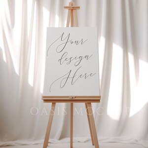Könnte beinhalten: Ein weißer Staffelei mit einem leeren Zeichenbrett, auf dem "Your design here" steht. Die Staffelei ist aus Holz und steht auf einer weißen Oberfläche.