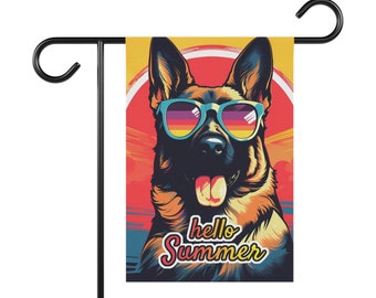 May include: A colorful garden flag featuring a German Shepherd dog wearing blue sunglasses. The dog is looking directly at the viewer with its tongue sticking out. The background is a sunset with the text "hello summer" in a retro font.