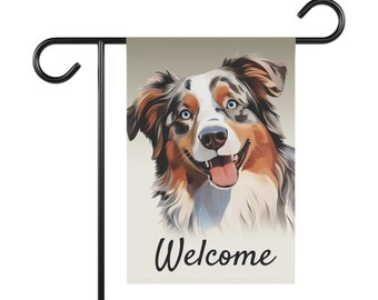 Peut inclure: Un drapeau de jardin avec un chien australien berger bleu merle aux yeux bleus et une langue rose. Le chien regarde la caméra et sourit. Le drapeau a le mot "Bienvenue" imprimé en noir.