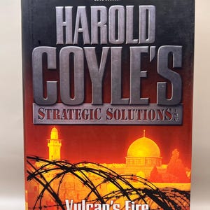 Könnte beinhalten: Buchcover für "Vulcan's Fire" von Harold Coyle und Barrett Tillman. Das Cover zeigt einen roten Hintergrund mit einem Stacheldrahtzaun im Vordergrund und einer Moschee im Hintergrund. Der Titel "Vulcan's Fire" ist in großen weißen Buchstaben.