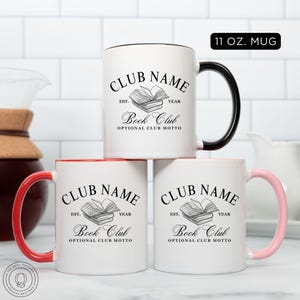 May include: White ceramic mugs with black, red, and pink handles. Each mug features the text "CLUB NAME" above a stack of books, with "Book Club" below. The mugs are 11 oz.