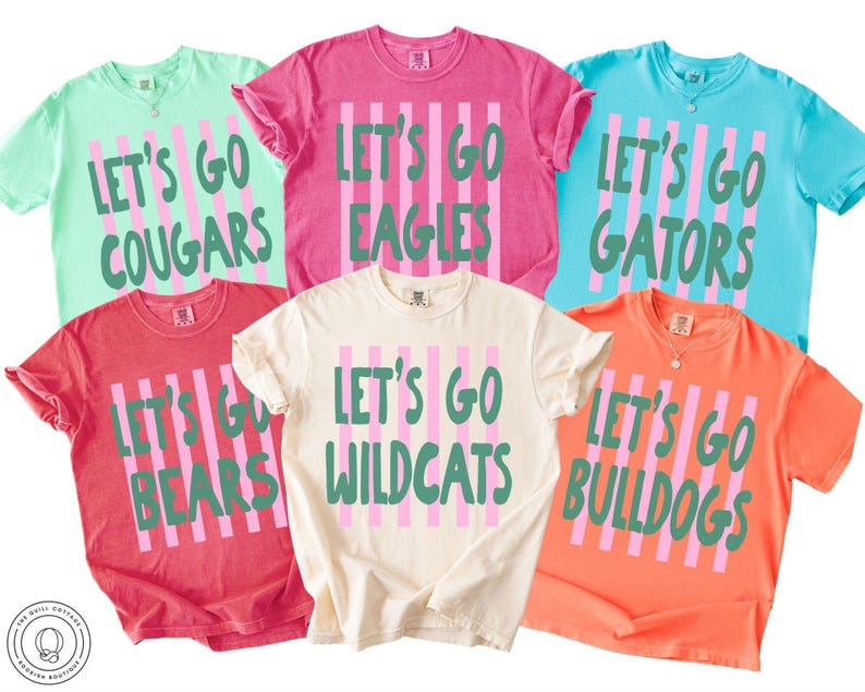 May include: Six short-sleeved crew neck t-shirts in mint, pink, light blue, red, cream, and orange. Each shirt features vertical pink stripes and green text reading Let's Go followed by team names: Cougars, Eagles, Gators, Bears, Wildcats, and Bulldogs.