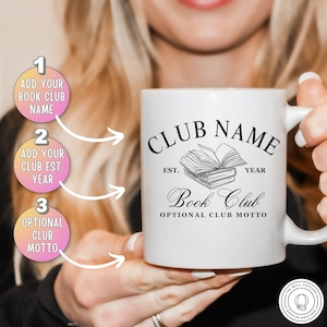 May include: White ceramic mug with the text "CLUB NAME" and "Book Club" in black script. The mug features an illustration of stacked books and the words "EST. YEAR" above the books. The mug has a handle and is held by a person.