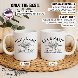 May include: Two white ceramic mugs with black text and a book club design. The front of the mug reads "CLUB NAME" above a stack of books and "Book Club." The back of the mug has the same design. The mugs are on a woven surface.