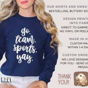 May include: A navy blue sweatshirt with the text 'go team. sports. yay.' printed in white. The sweatshirt is made in the USA and is custom made within 1-4 days. The text 'OUR SHIRTS AND SWEATS BESTSELLING, BUTTERY SOFT' is printed in white on the right side of the image. The text 'DESIGN PRINTED INTO FABRIC DIRECT TO GARMENT NO VINYL OR PEELING' is printed in white on the right side of the image. The text 'MADE IN USA CUSTOM MADE WITHIN 1-4 DAYS' is printed in white on the right side of the image. The text 'CUSTOM ORDERS WE LOVE DESIGNING FOR YOU - SEND US A MESSAGE' is printed in white on the right side of the image. The text 'THANK YOU!!' is printed in white on the right side of the image. A small image of a dog is printed in the bottom right corner of the image.
