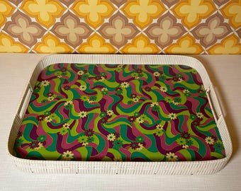 May include: White wicker serving tray with a colorful, psychedelic pattern of green, purple, and white swirls and flowers.