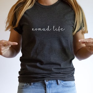 K&ouml;nnte beinhalten: Ein dunkelgraues T-Shirt mit dem Schriftzug "Nomad Life" in Wei&szlig; auf der Vorderseite.