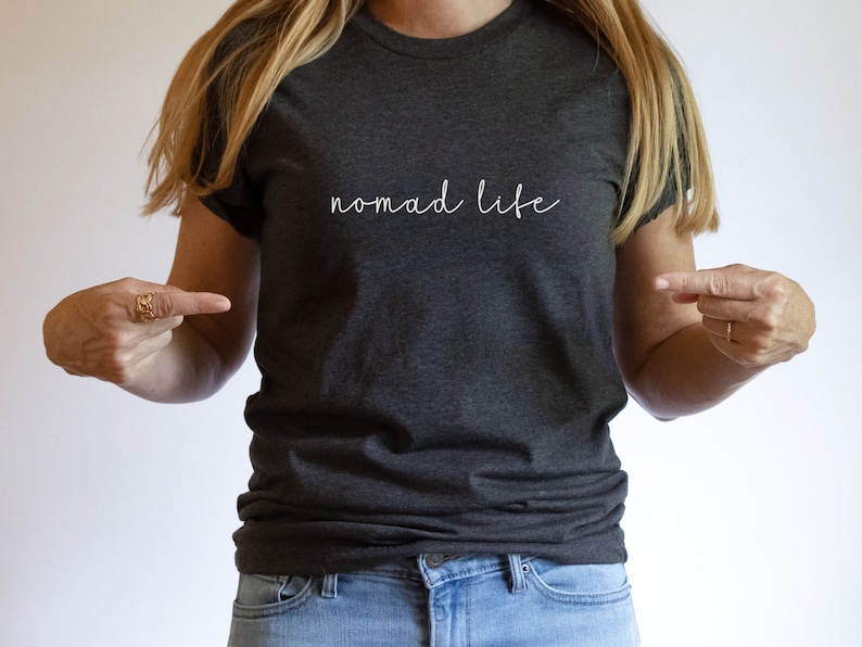 K&ouml;nnte beinhalten: Ein dunkelgraues T-Shirt mit dem Schriftzug "Nomad Life" in Wei&szlig; auf der Vorderseite.