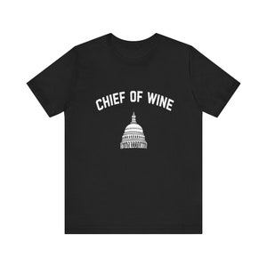 May include: Black t-shirt with white text that reads "Chief of Wine" and a white silhouette of the US Capitol building.