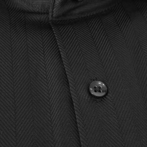 May include: A black dress shirt with a herringbone pattern and two black buttons.