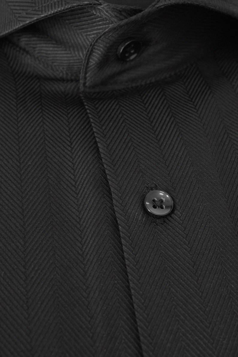 May include: A black dress shirt with a herringbone pattern and two black buttons.