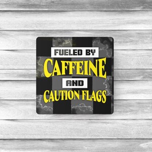 May include: Square design with a black and white chequered pattern, featuring the text "FUELED BY CAFFEINE AND CAUTION FLAGS" in yellow and white. The background has a cloudy effect.