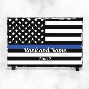 May include: Black and white American flag with a blue stripe across the bottom. The text "Rank and Name" and "Line 2" is printed below the blue stripe.