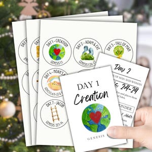 May include: A set of seven printable cards with watercolor illustrations depicting the seven days of creation. Each card features a different illustration and the corresponding Bible verse. The cards are titled "Day 1 Creation" through "Day 7 Jacob".