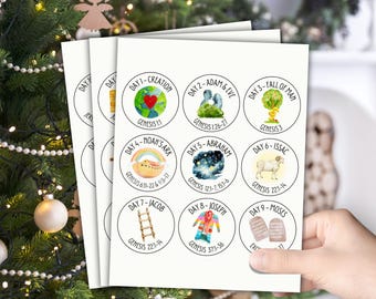 Op de afbeelding: Een stapel van negen ronde stickers met aquarel illustraties die bijbelse gebeurtenissen uitbeelden. Elke sticker toont een andere scène, waaronder de Schepping, Adam en Eva, de Ark van Noach en Mozes. De tekst "Day 1-Creation" en "Genesis 1:1" is zichtbaar.