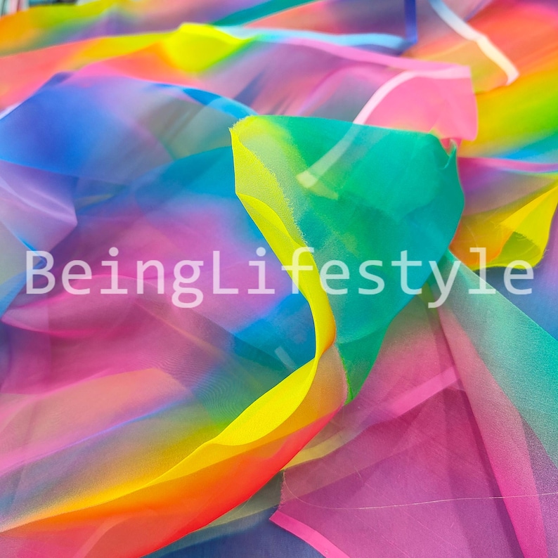 May include: A close-up of colorful fabric in shades of pink, yellow, green, blue, and orange. The fabric is translucent and layered, with the text "BeingLifestyle" in white.