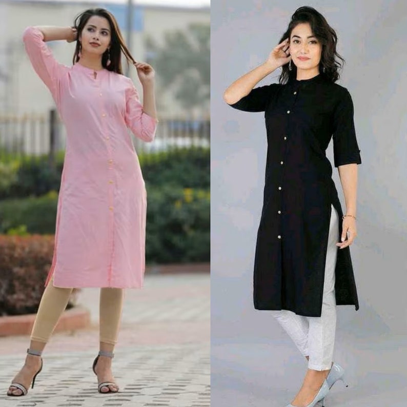 May include: Two women wearing long-sleeved button-down shirts. The shirt on the left is pink and the shirt on the right is black. Both shirts have a long, straight cut and a button-up front.