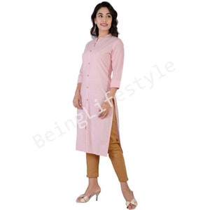 May include: A long-sleeved pink button-down shirt with a mandarin collar. The shirt is made of a lightweight fabric and has a relaxed fit.