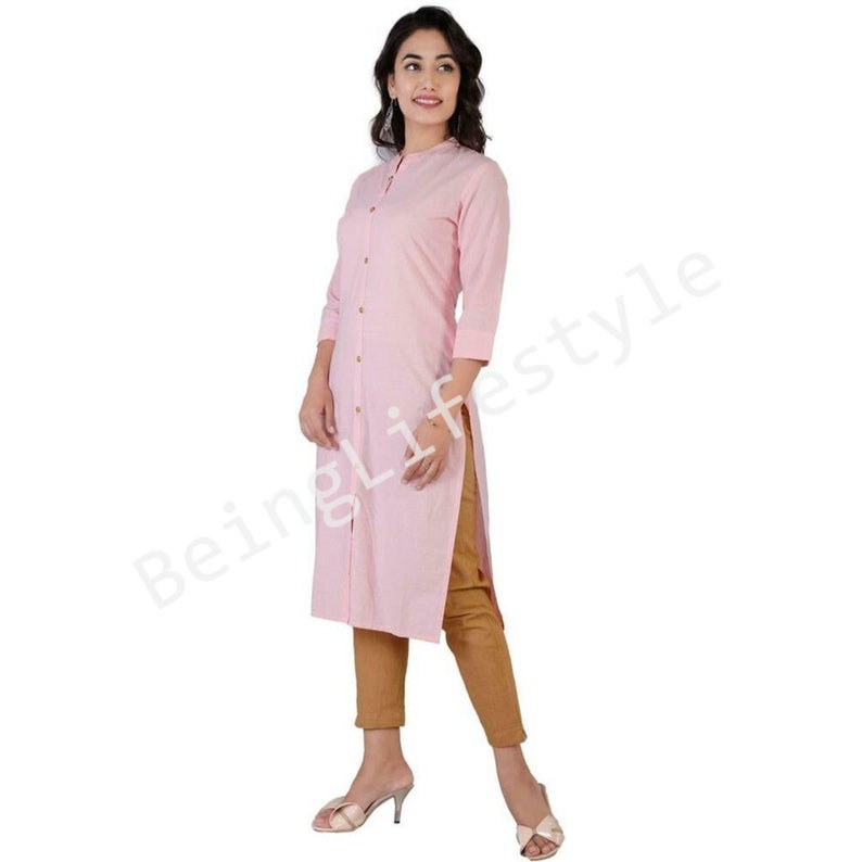 May include: A long-sleeved pink button-down shirt with a mandarin collar. The shirt is made of a lightweight fabric and has a relaxed fit.