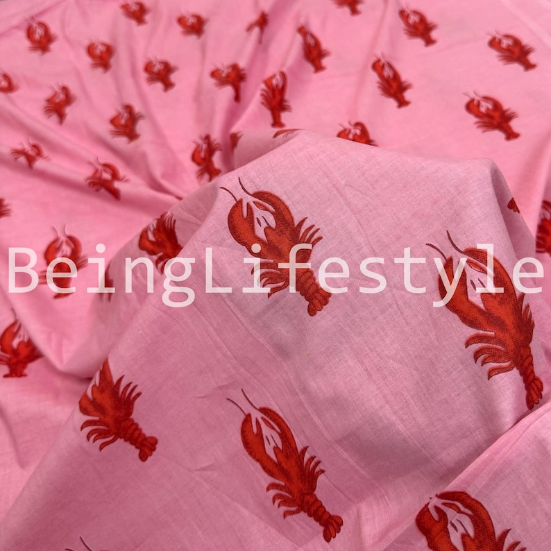 Puede incluir: Tela rosa con un patr&oacute;n repetido de langostas rojas. La tela est&aacute; doblada, revelando el patr&oacute;n y el texto "BeingLifestyle".