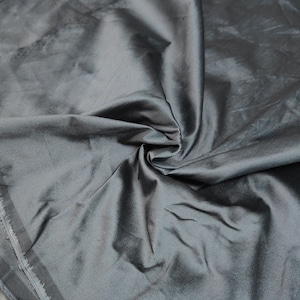 May include: A smooth, dark gray fabric with a subtle sheen. The fabric is folded and draped, showcasing its texture and drape.