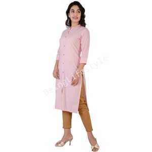May include: A pink long-sleeved button-down shirt with a mandarin collar. The shirt has a side slit and is made of a lightweight fabric.