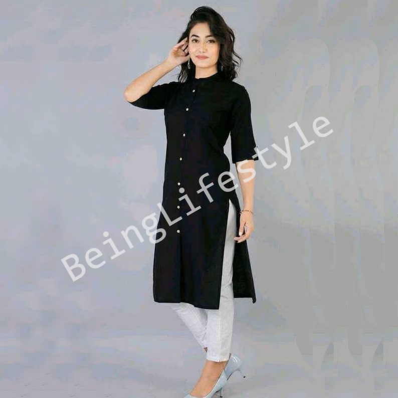 May include: A black long-sleeved kurta with a button-up front and a side slit. The kurta is worn with white trousers and black heels.