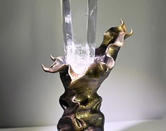 Ponta de cristal de quartzo transparente grande com formação semelhante a uma montanha, suporte para cálice artesanal em preto e dourado, decoração energética.