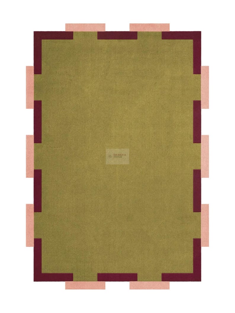 May include: A rectangular rug with a central olive green field, framed by a border of alternating burgundy and light pink rectangular blocks. The rug has a simple, geometric design.