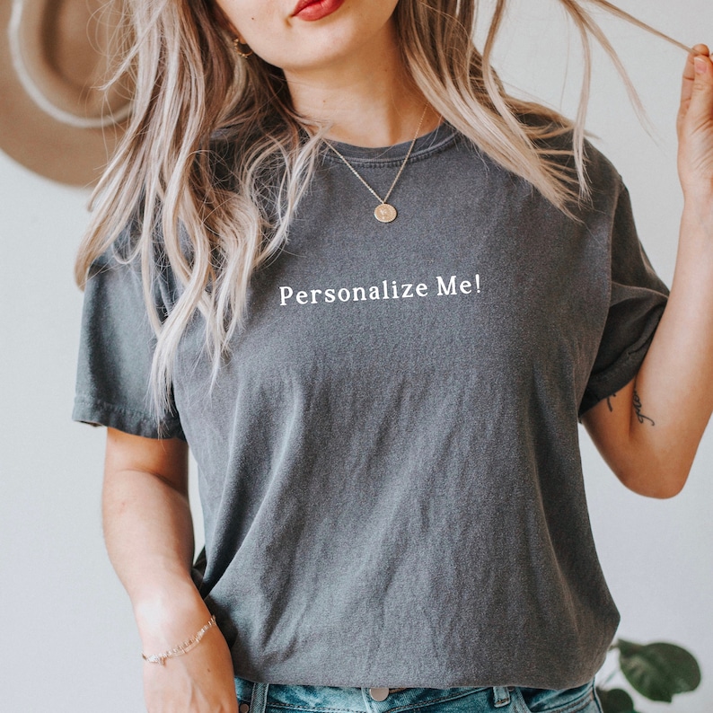May include: A dark gray t-shirt with the text "Personalize Me!" printed in white on the front.