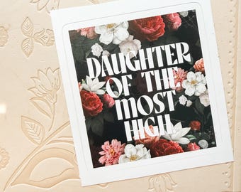 Puede incluir: Una pegatina cuadrada con un fondo oscuro lleno de ilustraciones florales en tonos rojos, rosas y blancos vibrantes. El texto blanco en negrita en el centro dice DAUGHTER OF THE MOST HIGH en una fuente limpia, creando un diseño de alto contraste.