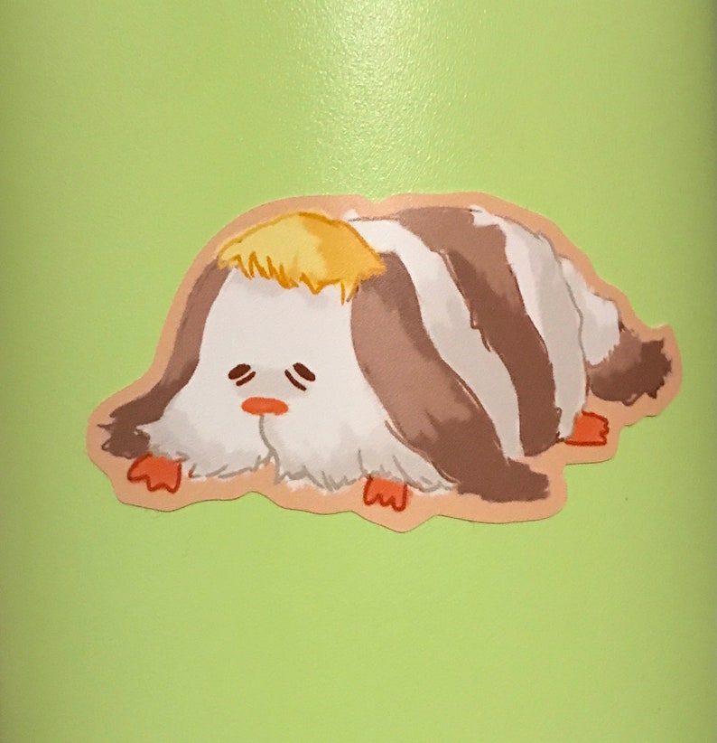 May include: A sticker featuring a cartoon creature with a white body, brown and white stripes, and a yellow tuft of hair. The creature has a sad expression with small eyes and a small orange nose. The sticker is on a light green background.