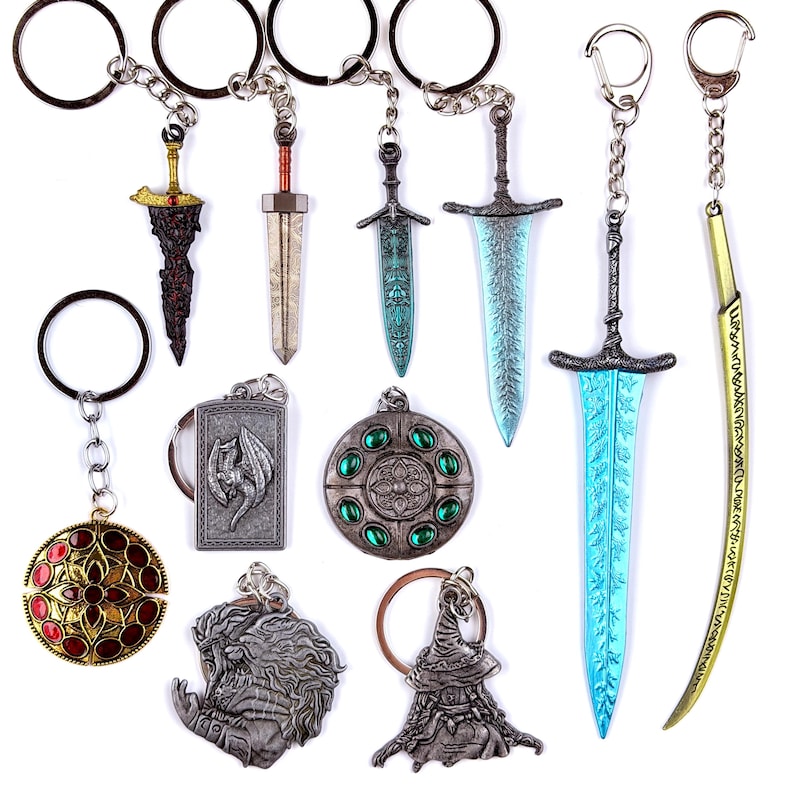 May include: A collection of metal keychains featuring various sword designs, including blue and gold blades, along with circular and rectangular pendants decorated with embossed dragon motifs, floral patterns, and inset red and green stones.