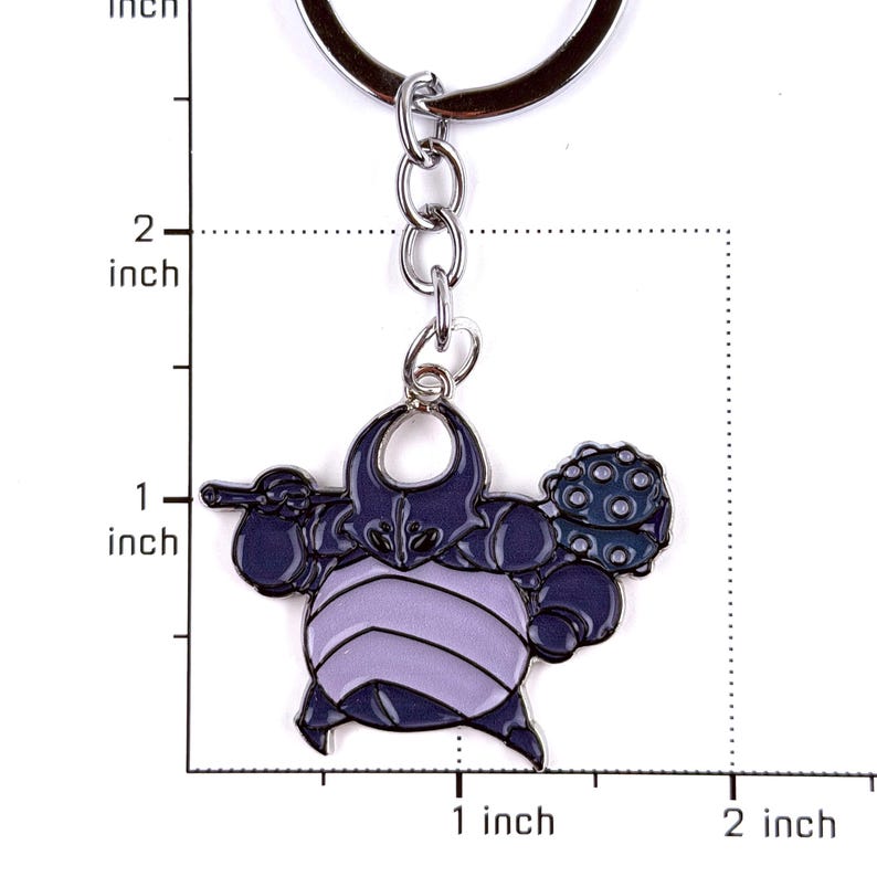 May include: A metal keychain featuring a dark purple and light lavender character charm with a spiked club. The charm is attached to a silver-colored split ring. A ruler graphic indicates the charm is approximately 1 inch wide and 1 inch tall.
